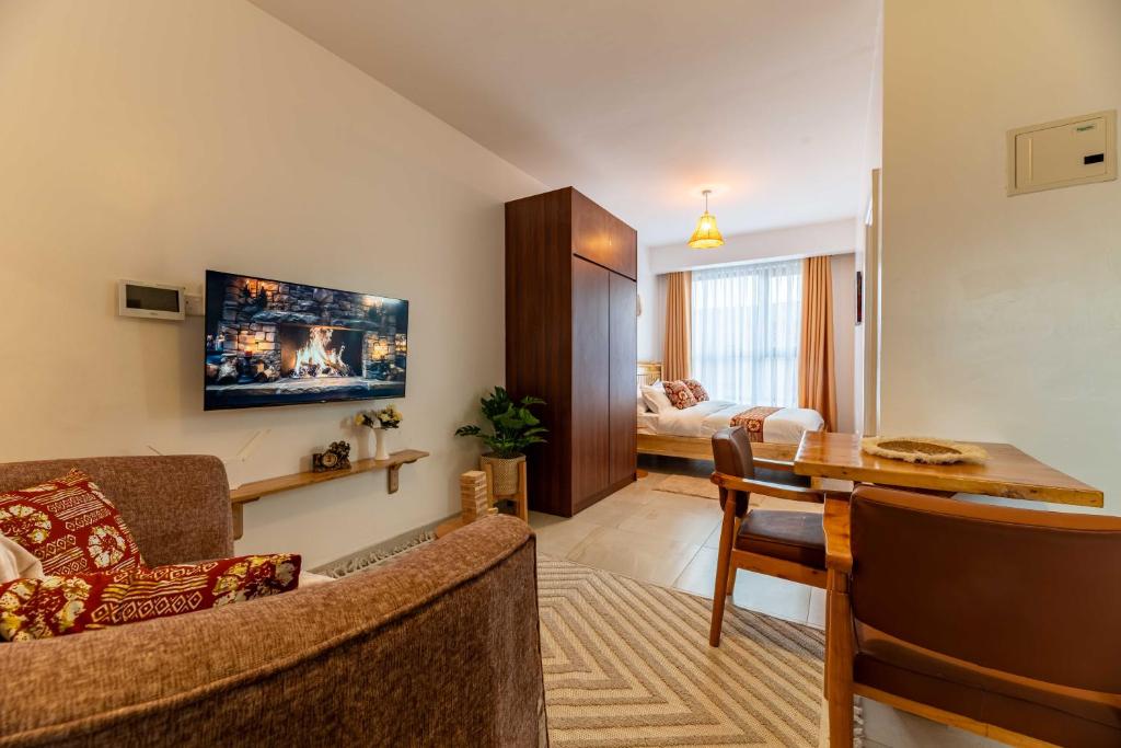 a living room with a couch and a dining room at Lorien Homes in Nairobi