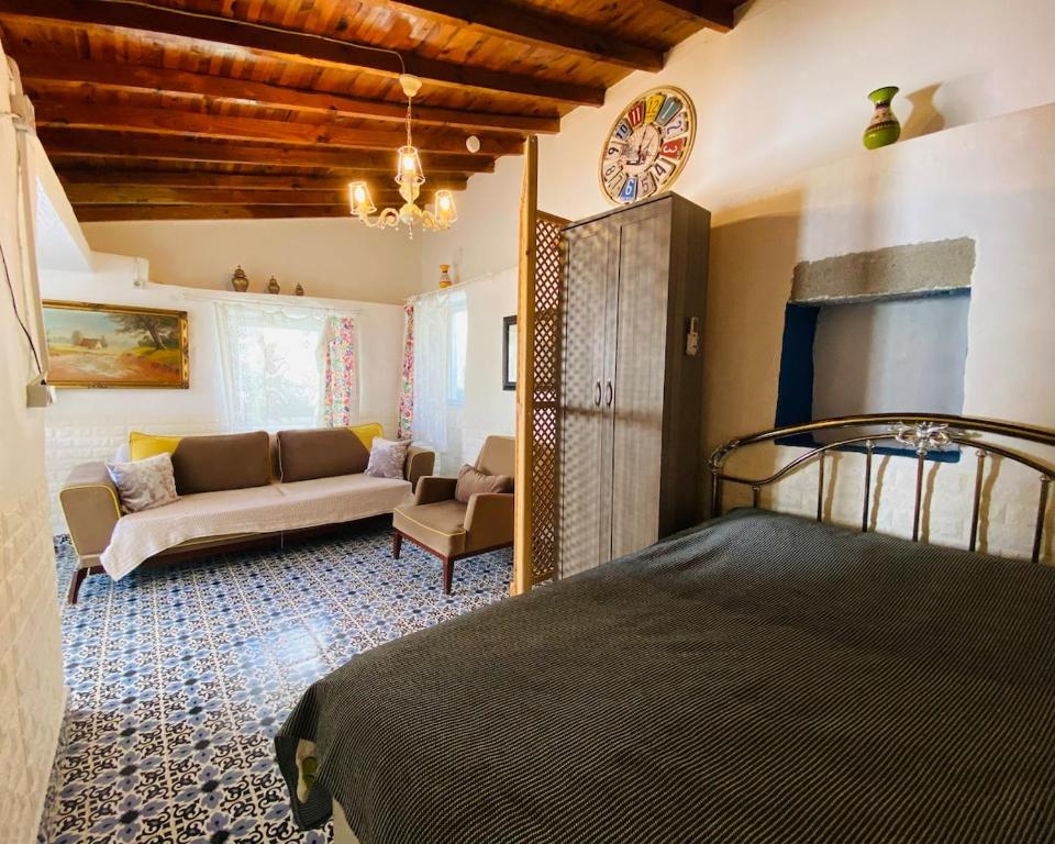 a bedroom with a bed and a couch in a room at Badehan Guest House in Cesme