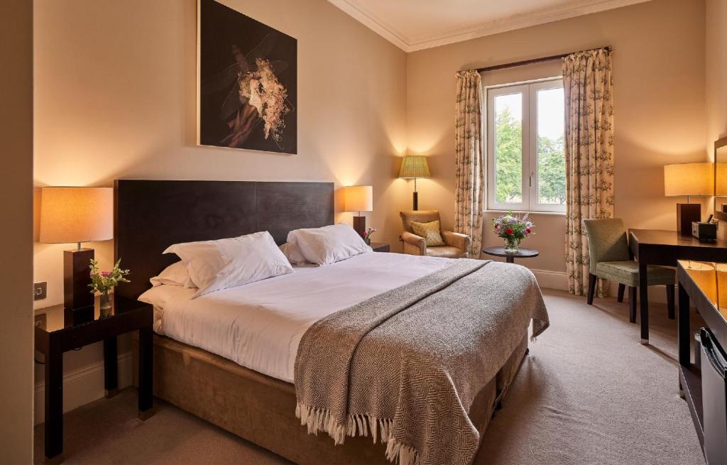 Un dormitorio con una cama grande y un escritorio. en Badam Hotel, en Ganja