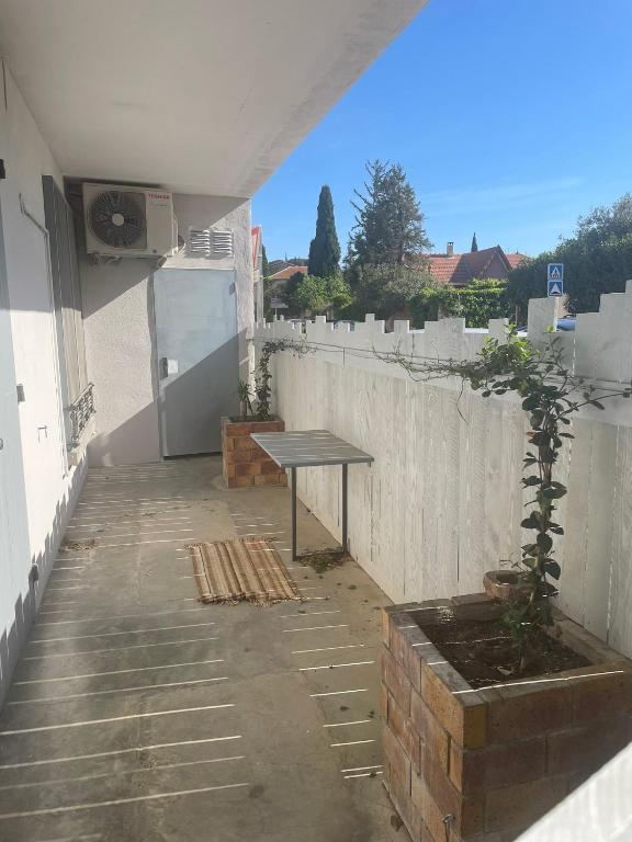 a picnic table sitting on the side of a building at Sur la route des vignerons - Clim - 1 Chambre in Courthézon