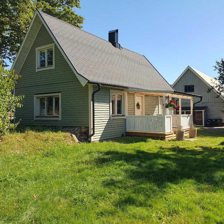 a green house with a lawn in front of it at Cozy countryside retreat near Söderåsen National Park in Svenstorp