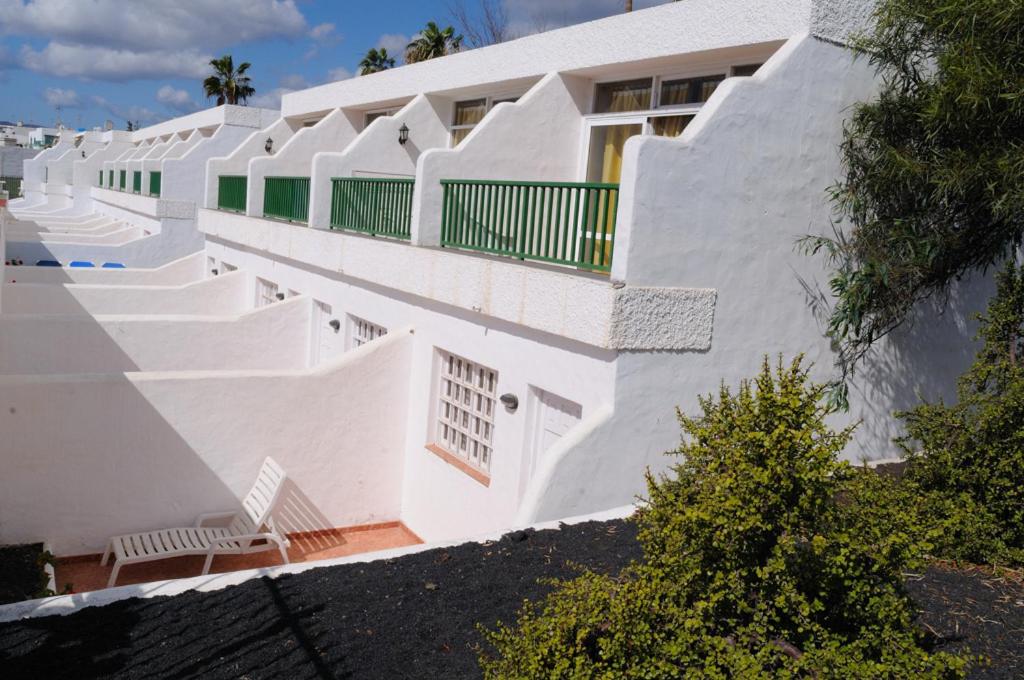 un edificio blanco con paredes y escaleras blancas en Apartamentos Guanarama, en Puerto del Carmen