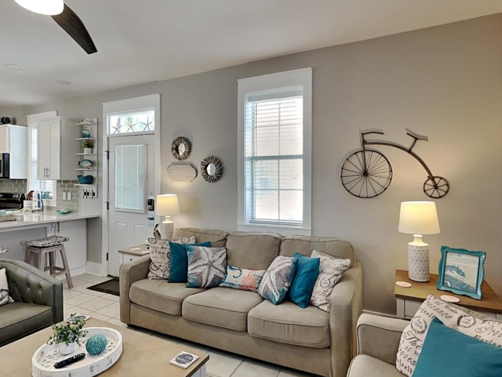 sala de estar con sofá y bicicleta en la pared en Bungalows at Seagrove #138, en Seagrove Beach