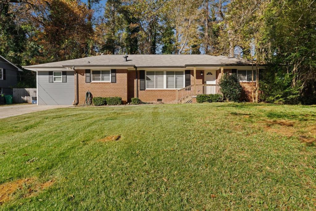 a house with a large lawn in front of it at Elegant 4BDR Atlanta Home Perfect for Families in Stone Mountain
