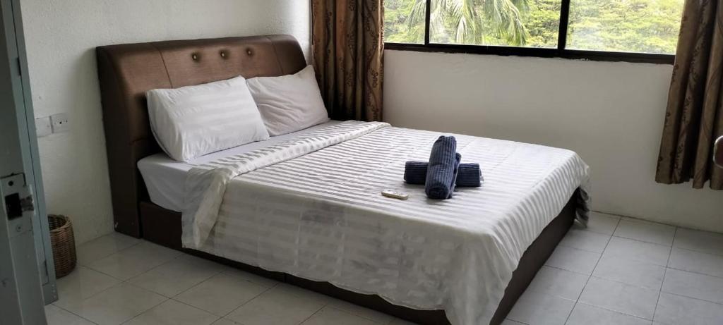 a bedroom with a bed with a phone on it at sri sayang apartment in Batu Ferringhi