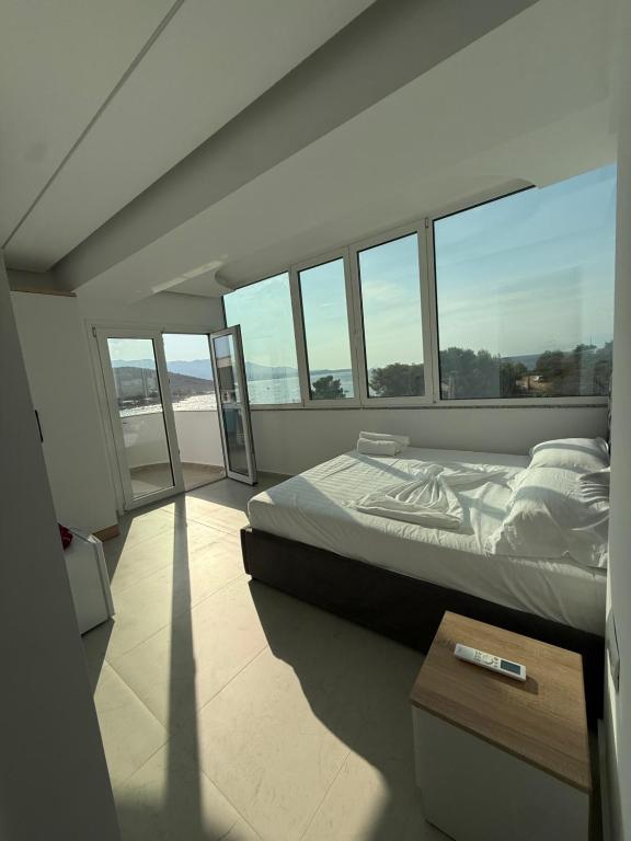 - une chambre avec un grand lit et des fenêtres dans l'établissement Dashaj Rooms 304, à Ksamil