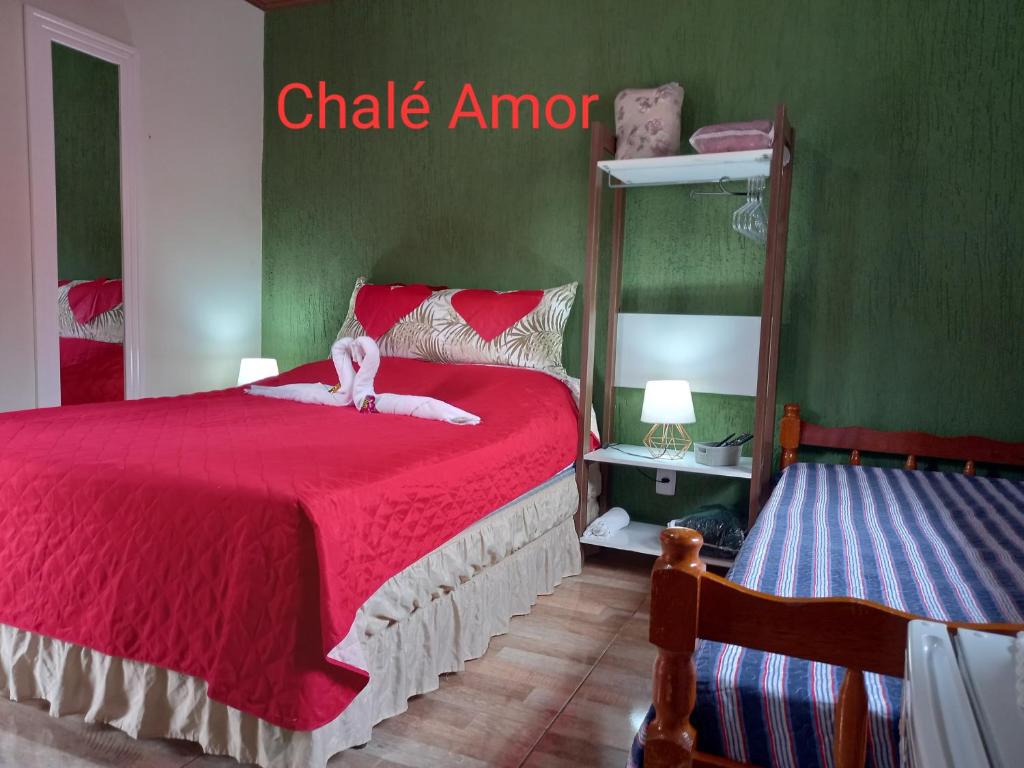a bedroom with a red bed with a dog on it at Chalés Mimar Lumiar Suítes independentes in Lumiar