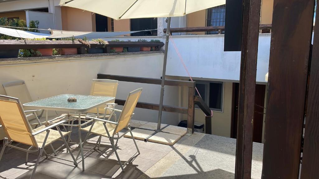 a table and chairs on a balcony with an umbrella at La taverna del mare in Civitavecchia