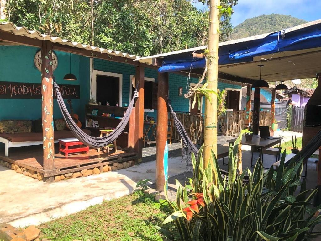 une maison avec un hamac à l'extérieur dans l'établissement Macondo Hostel Itamambuca, à Praia de Itamambuca