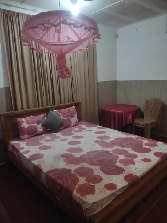 - une chambre avec un grand lit fleuri dans l'établissement New Araliya Resort, à Anurâdhapura