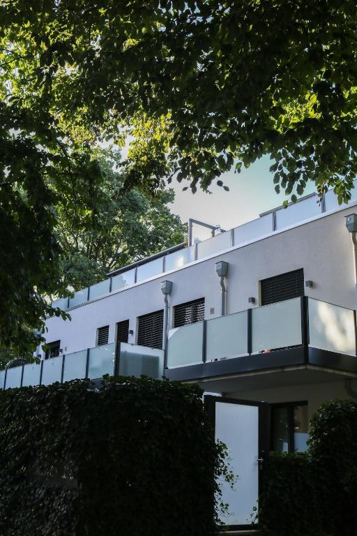 Un edificio blanco con un balcón en la parte superior. en Naemi Premium Apartment Hannover, en Langenhagen