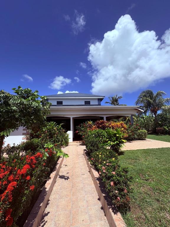 una casa con un jardín con flores delante en Villa Ti Flè, en Saint-François