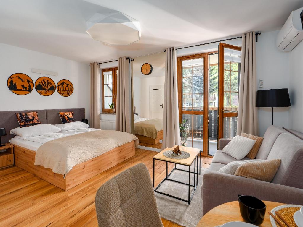 a bedroom with a bed and a living room at Apartament Królewski w centrum Nad Łomnicą 15 in Karpacz