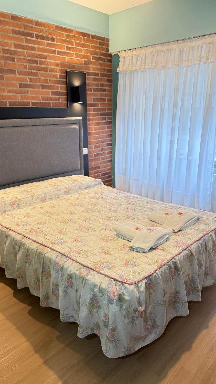 a large bed in a room with a brick wall at Diplomat Hotel in Buenos Aires