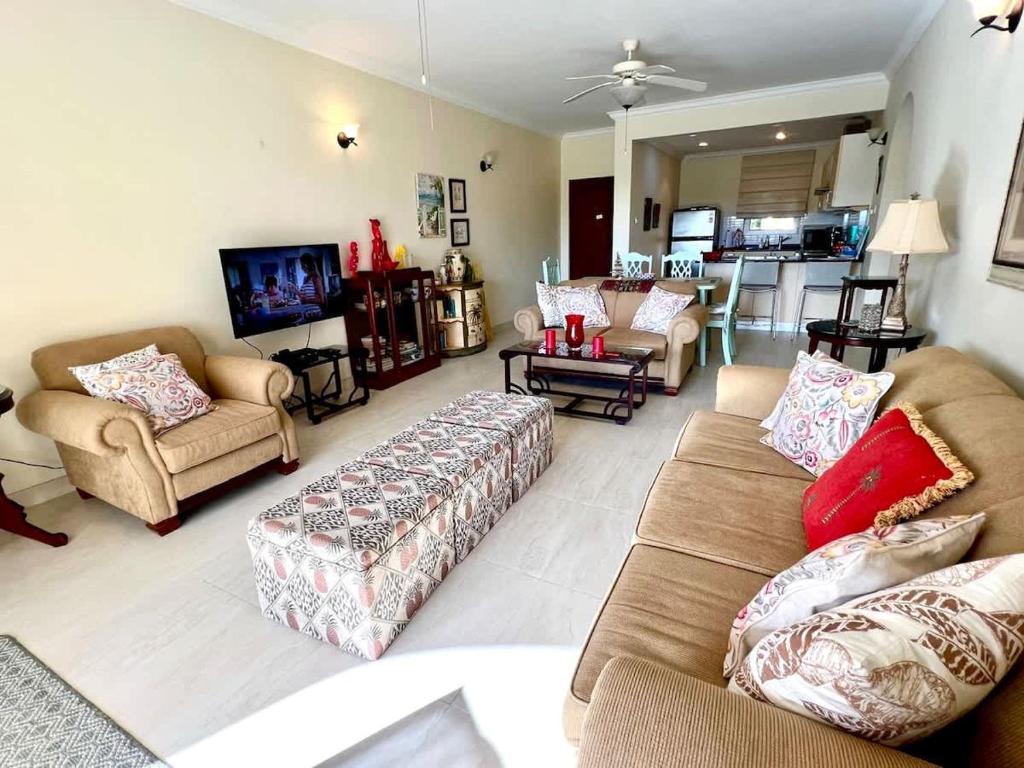 a living room with couches and chairs and a kitchen at ZenBreak Island Time at El Sol in Christ Church