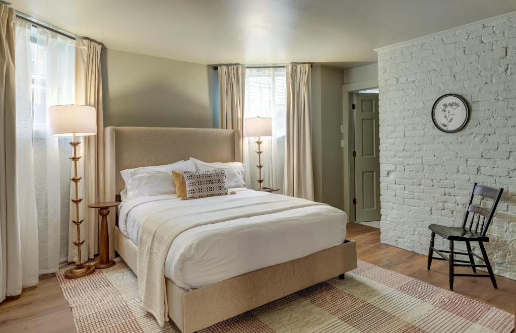 een slaapkamer met een bed en een klok aan de muur bij The 200 South St | Queen Rm 15 in Charlottesville