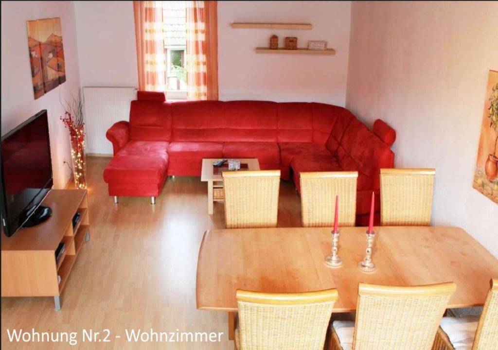 ein Wohnzimmer mit einem roten Sofa und einem Tisch in der Unterkunft Ferienwohnungen Schallenberg Nr 2 in Groß-Umstadt