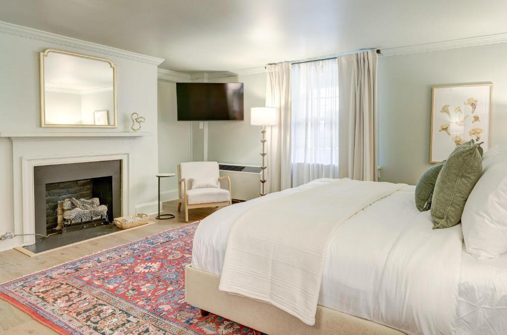 ein Schlafzimmer mit großem Bett und Kamin in der Unterkunft The 200 South St | King Rm 3 in Charlottesville