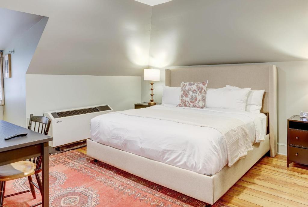 a bedroom with a large white bed and a desk at The 200 South St - King Rm 12 in Charlottesville