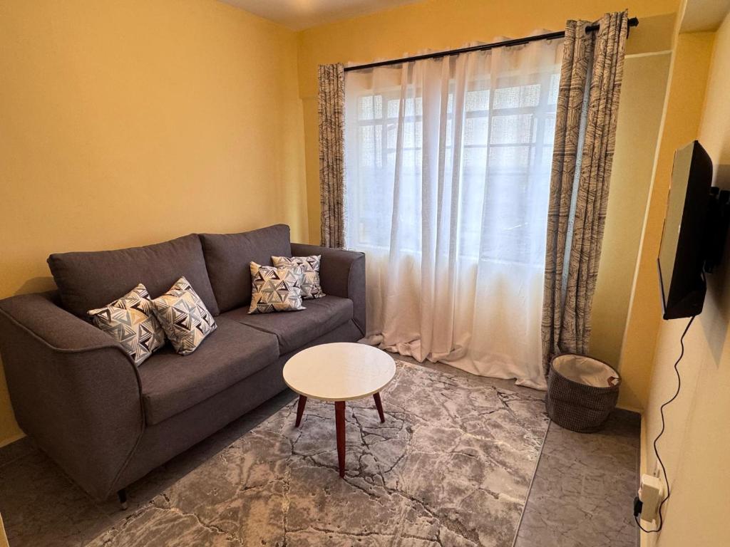 een woonkamer met een bank en een tafel bij The R&M Escapes in Kisumu