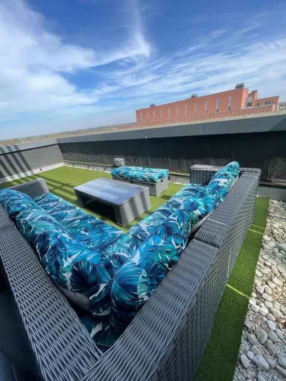 a group of blue cushioned benches on top of a building at Fast WiFi, Free Netflix 2 Bedroom Penthouse with Large Balcony in Slough
