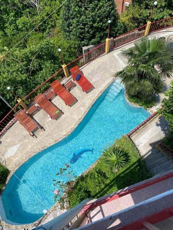 an overhead view of a swimming pool with chairs and trees at Yellow villa in Gonio in Gonio
