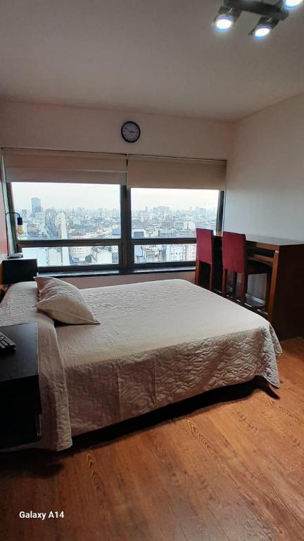 a bedroom with a large bed with a clock on the wall at Mía Apart in Buenos Aires