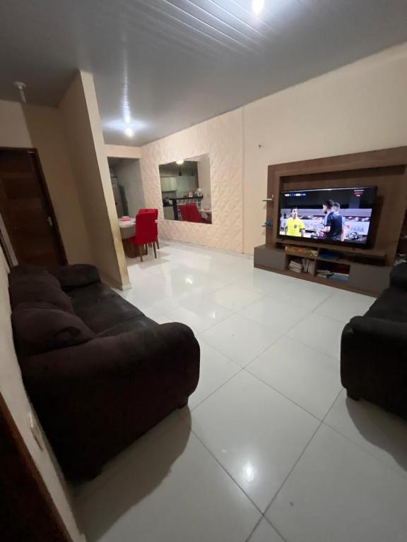 a living room with a couch and a flat screen tv at Casa in Ananindeua