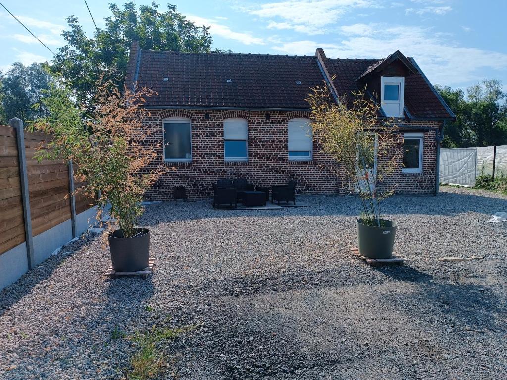 a house with two potted plants in front of it at la ferme du renard et son gîte 
