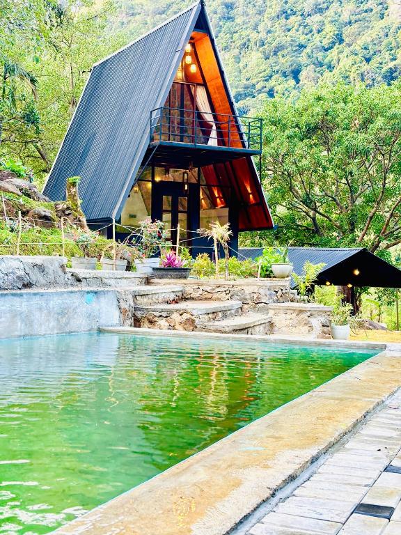 a building with a roof over a body of water at Bambarakanda eco resort in Welegama