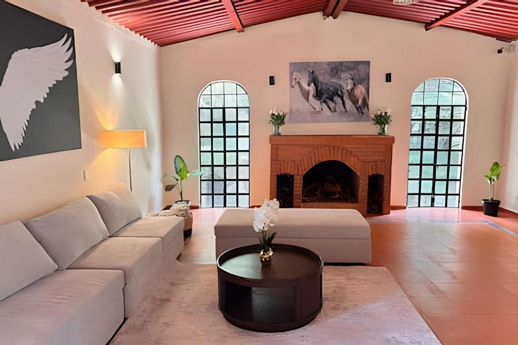 a living room with a couch and a fireplace at Suite entre árboles y fogata in El Hospital