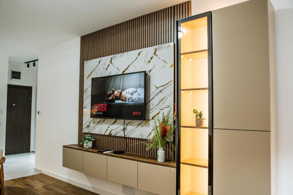 a living room with a tv on a wall at New Bubanj Apartment's in Kragujevac
