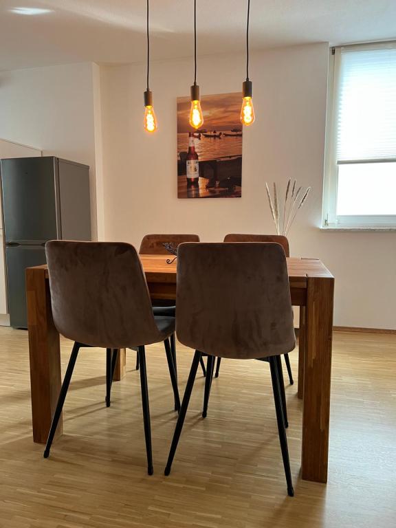 a dining room table with two chairs and a refrigerator at Tobi‘s Ferienapartment in Gottmadingen