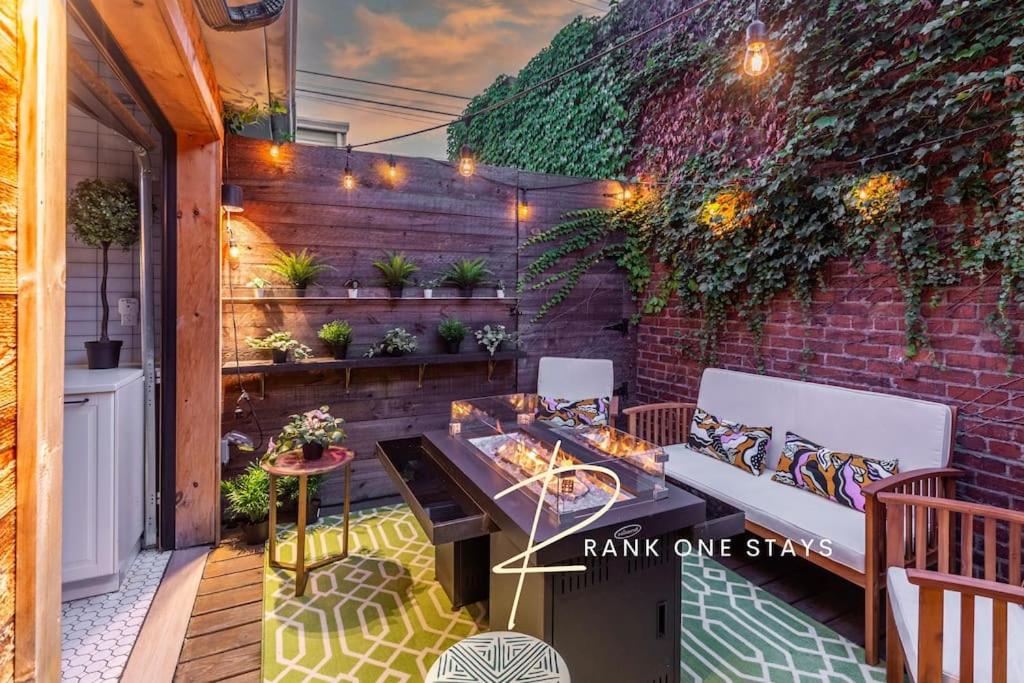 a patio with a table and chairs and a brick wall at Chic Home with King Bed and Fire Pit in Pittsburgh