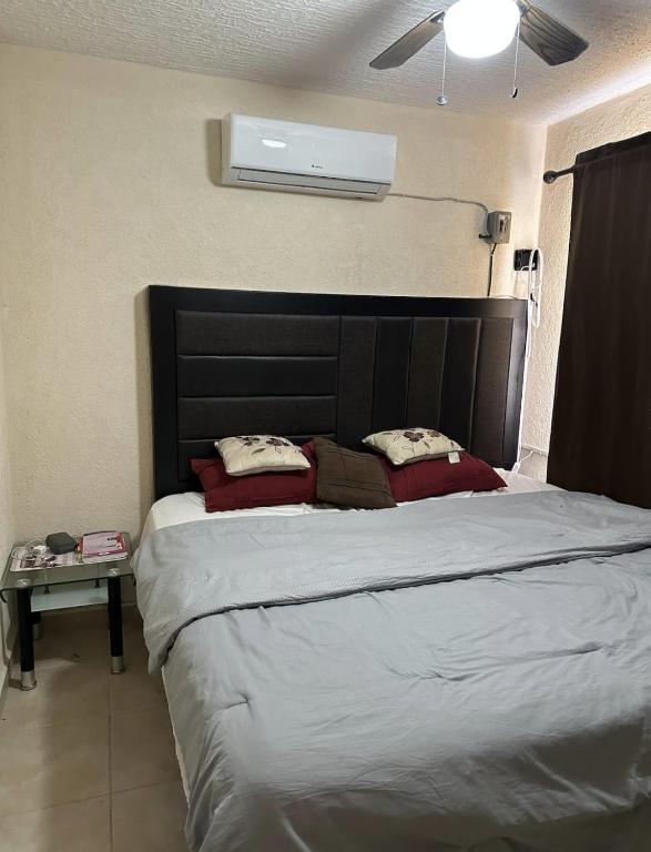 a bedroom with a large bed with a black headboard at Departamento en Zona Diamante Acapulco in Acapulco