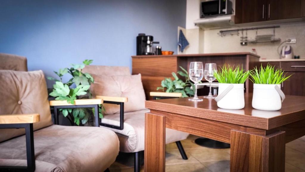 Un comedor con mesa y sillas con plantas. en Studio Comfort Blue, en Primorsko