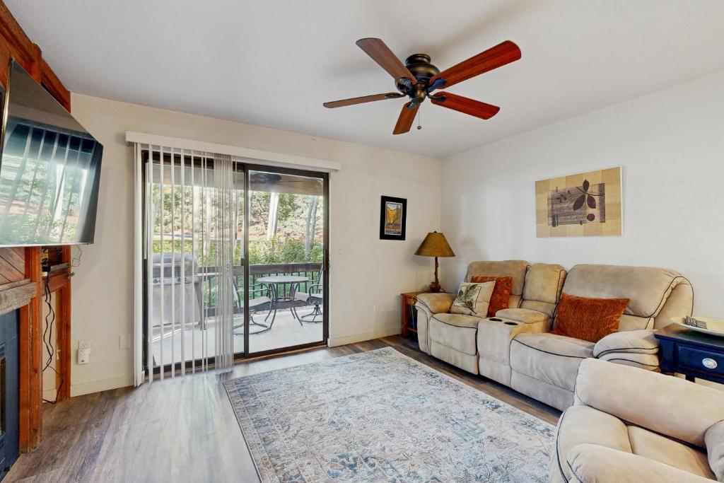 een woonkamer met een bank en een plafondventilator bij Majestic Charm in Park City