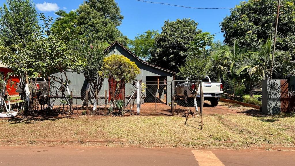 a house with a fence and a truck in front of it at Casa Rústica in Encarnación