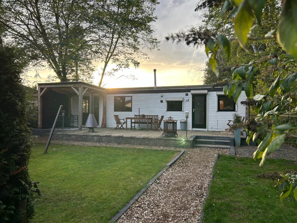 a small white caravan with a patio and grass at Welcome, relax and enjoy your stay in Putten