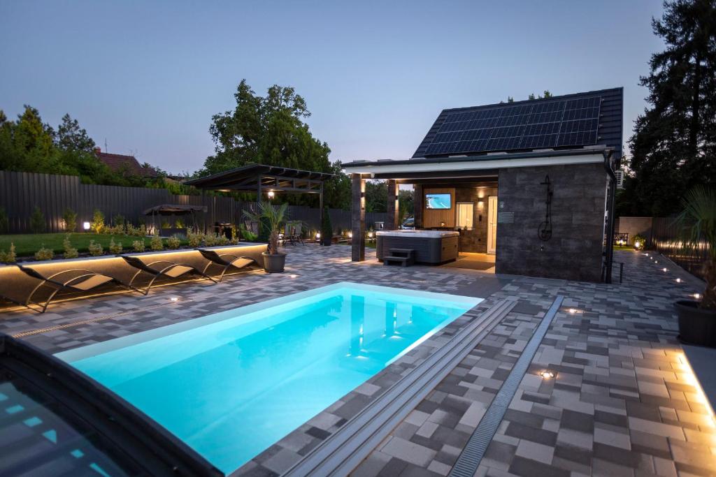 una piscina in un cortile con una casa di Gyopárosi Deluxe Private Wellness House 4 Csillag a Orosháza
