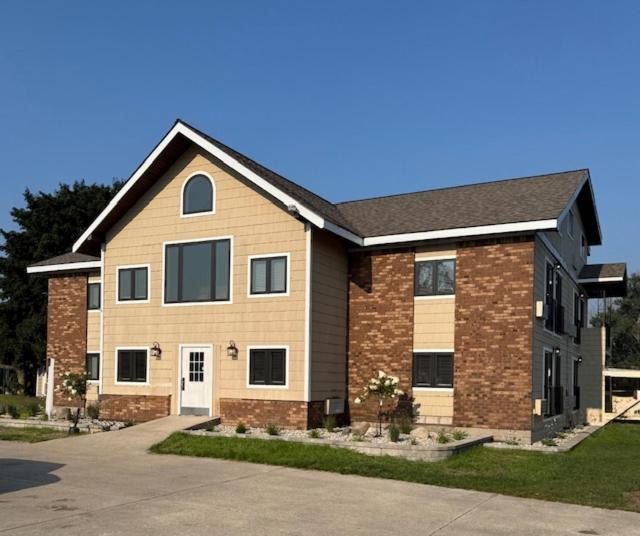a large brick house with a driveway at Mushroom Cap Motel in Mesick