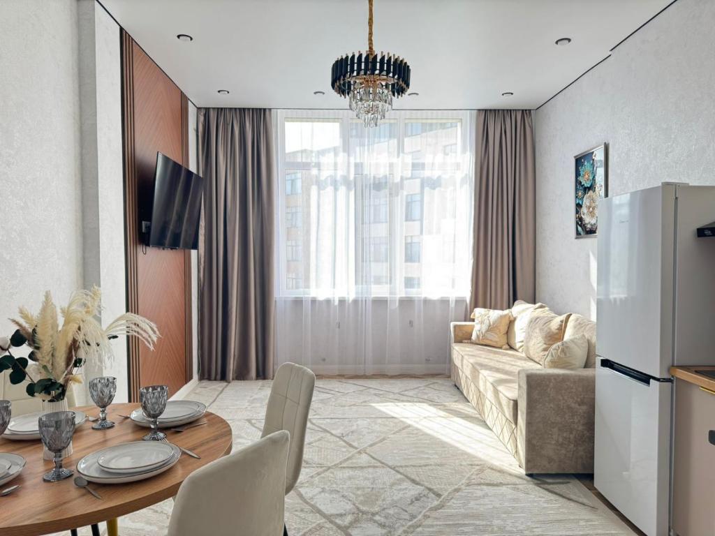 a living room with a table and a couch at Buhar Zhyray Exclusive-1 in Zhezdi