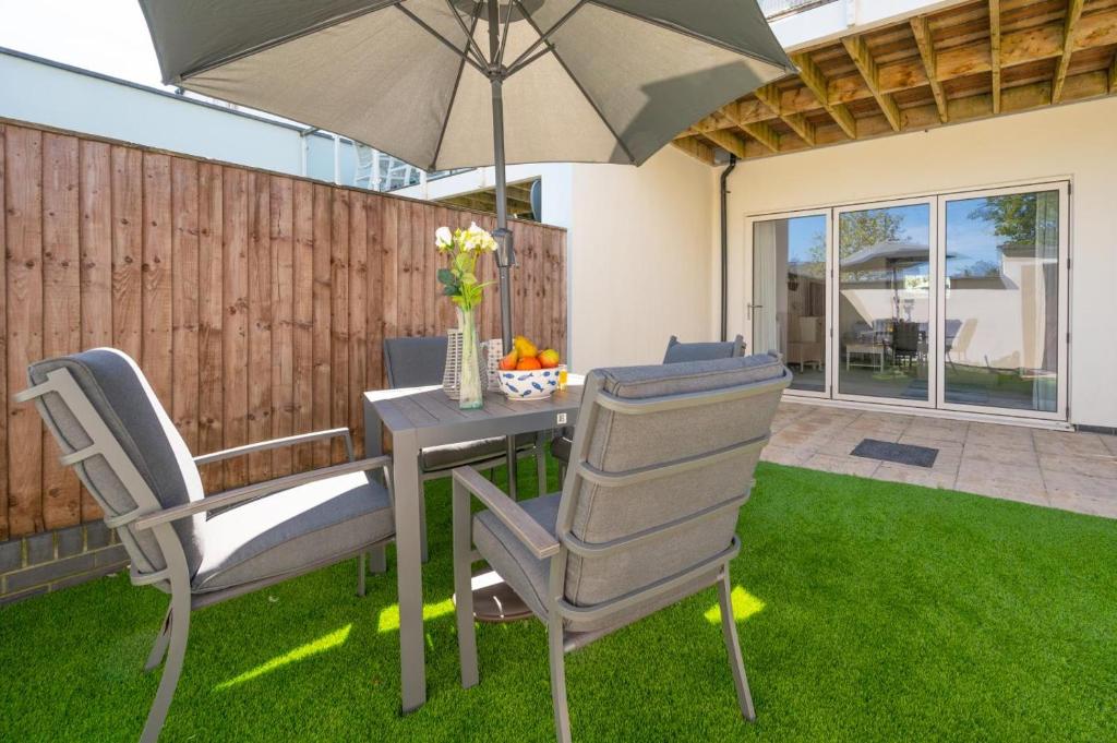 a table and chairs with an umbrella in a yard at The Sandbox in Saundersfoot