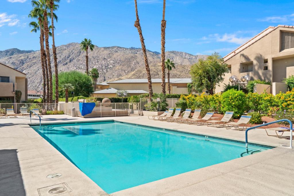 una piscina con sedie e palme di Sweet Citrus Condo a Palm Springs