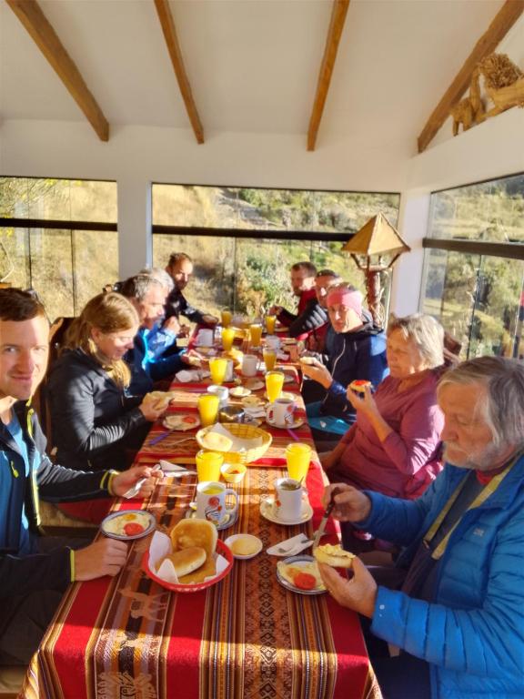 a group of people sitting around a table eating food at Palacio del Inca Lodge Isla del Sol in Comunidad Yumani