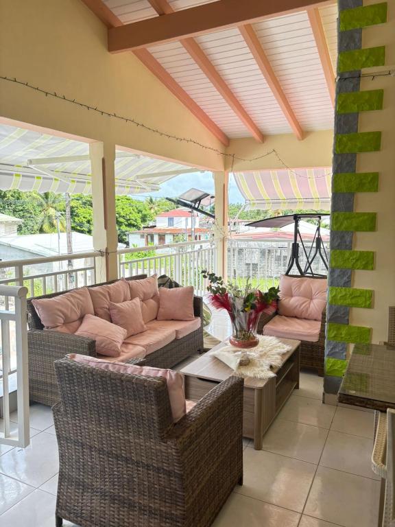 a patio with couches and a table and chairs at Secrète Paradise in Capesterre-Belle-Eau