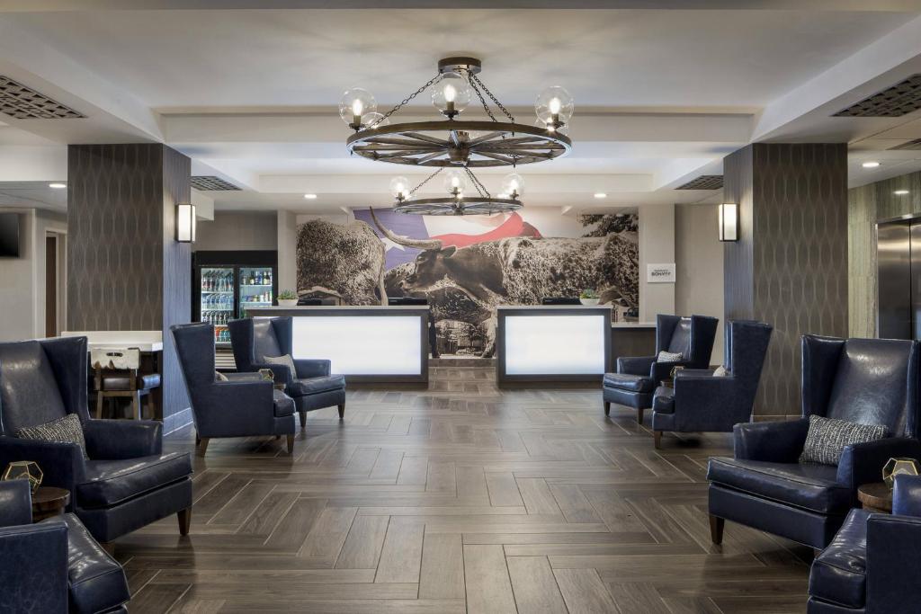 une salle d'attente avec des chaises et un lustre dans l'établissement Courtyard Fort Worth Downtown/Blackstone, à Fort Worth