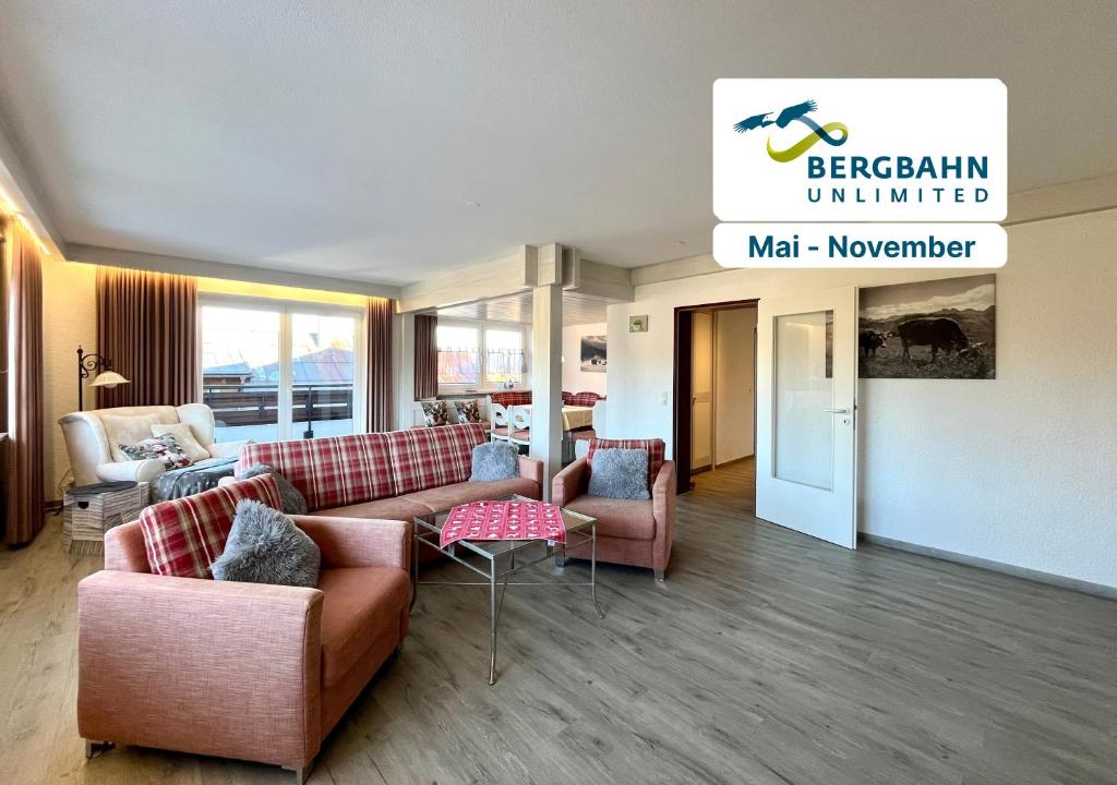 una sala de estar con sofás y sillas y un cartel en Bergsonne B15 Montana Haus, en Oberstdorf