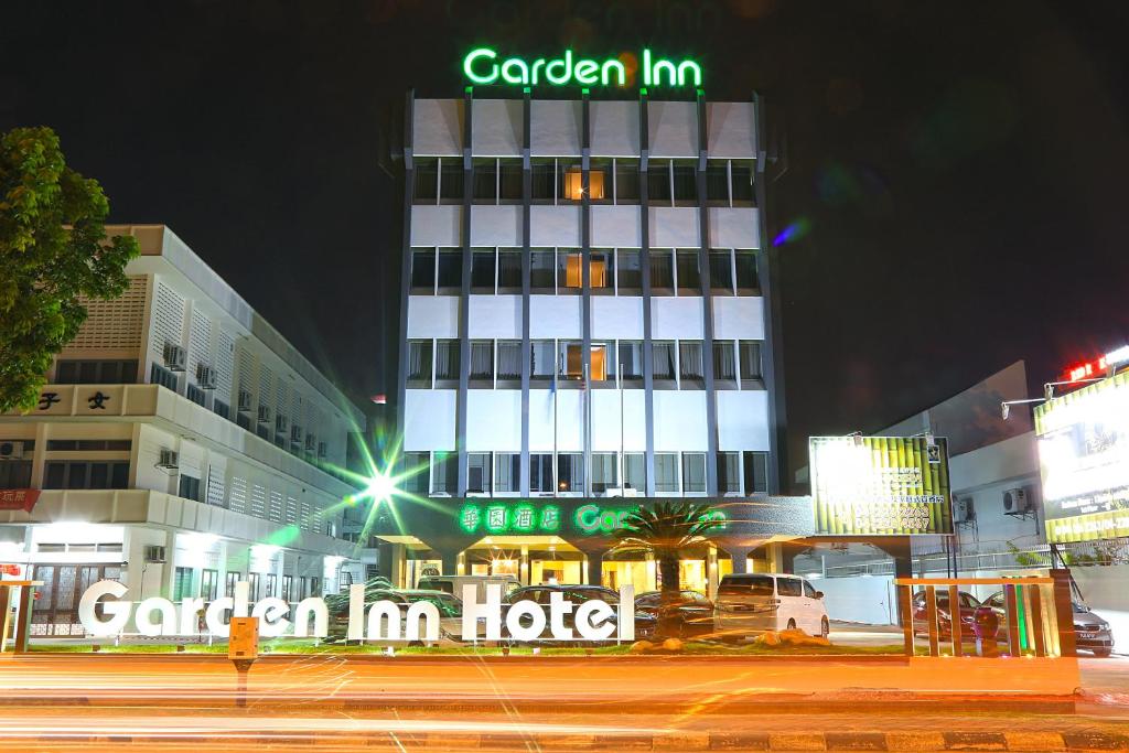 ein Gebäude mit einem grünen Schild darüber in der Unterkunft Garden Inn, Penang in George Town