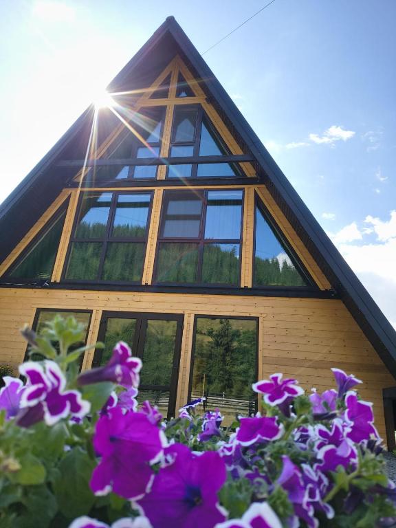 a house with a bunch of purple flowers in front of it at Rusca Retreat in Ruşca